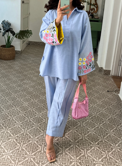 Woman wearing sky blue cotton co-ord set with floral embroidered sleeves and straight pants in Pakistani style casual fashion