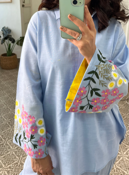 Woman wearing sky blue cotton co-ord set with floral embroidered sleeves and straight pants in Pakistani style casual fashion